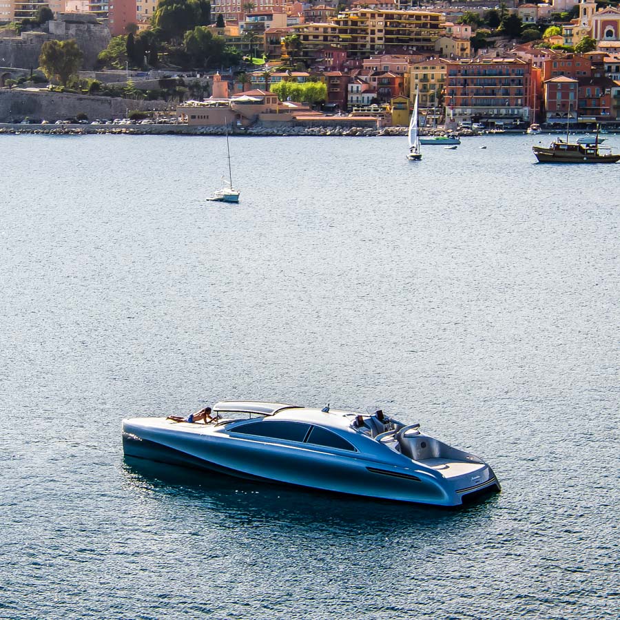 Mercedes-Benz Style Yacht in einer Bucht bei Monaco. Häuser im Hintergrund. Meer.