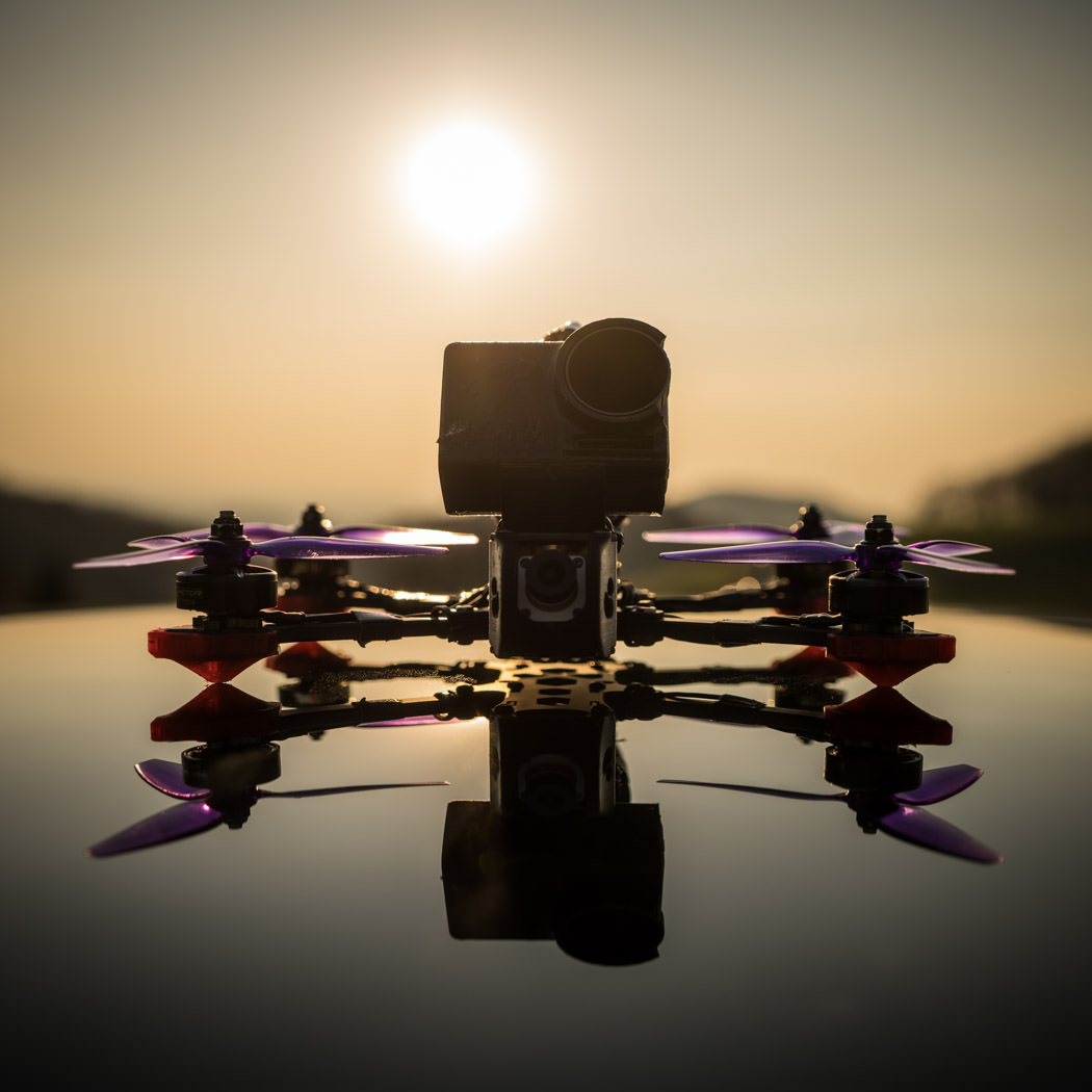 FPV Drohne auf Autodach im Sonnenuntergang